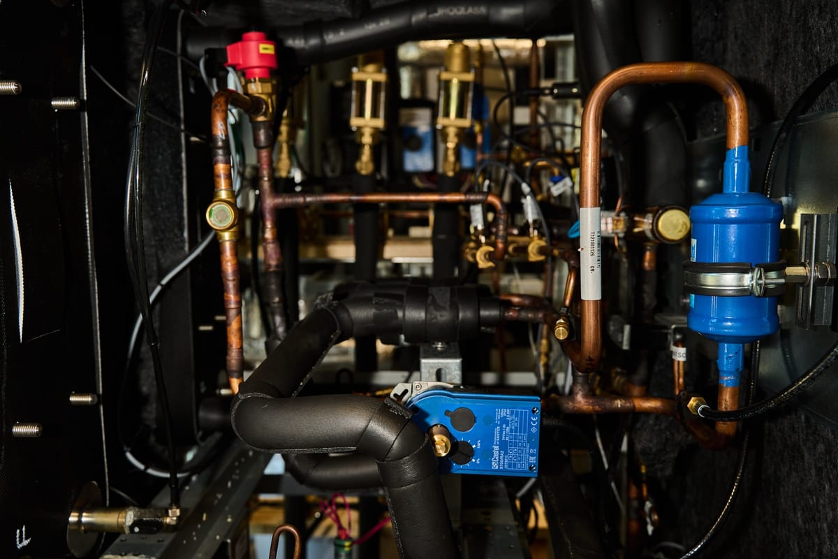 Copper refrigerant piping, brass valves, a filter drier and a blue actuator on the Expantec test rig