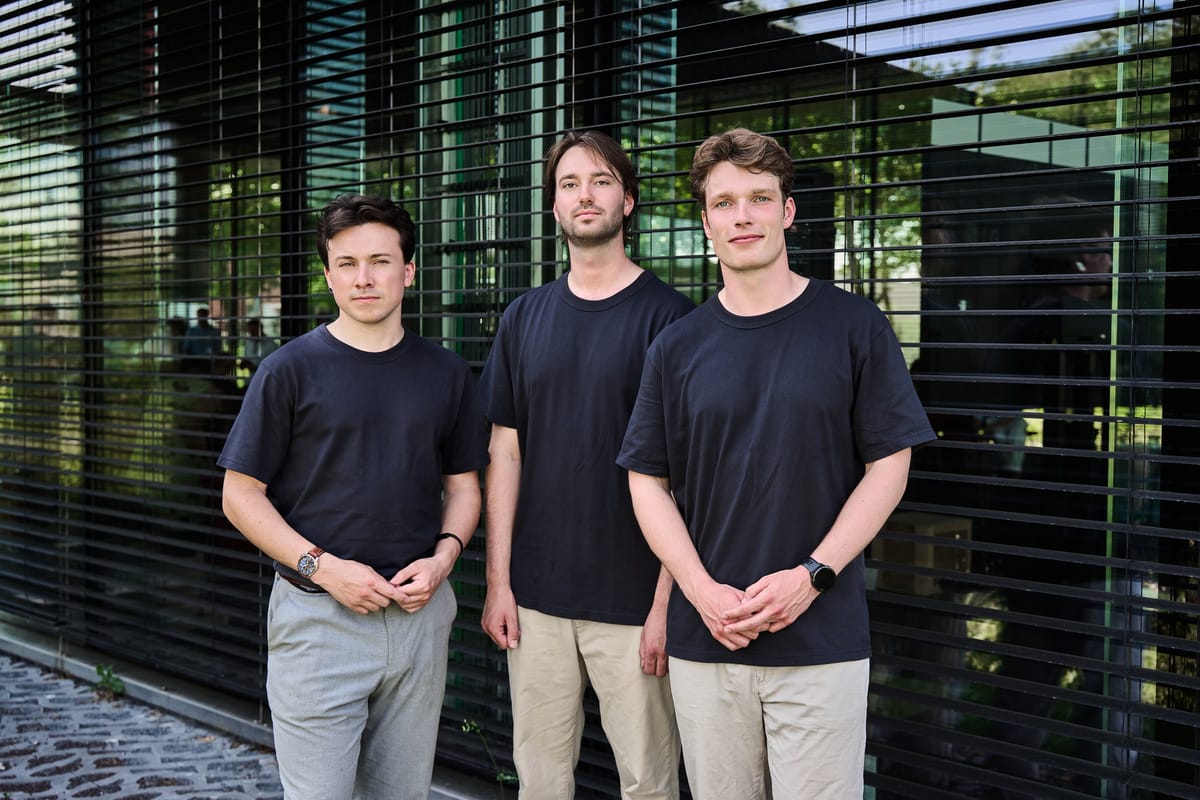 Three Expantec team members in front of the glass facade of the Yes!Delft building